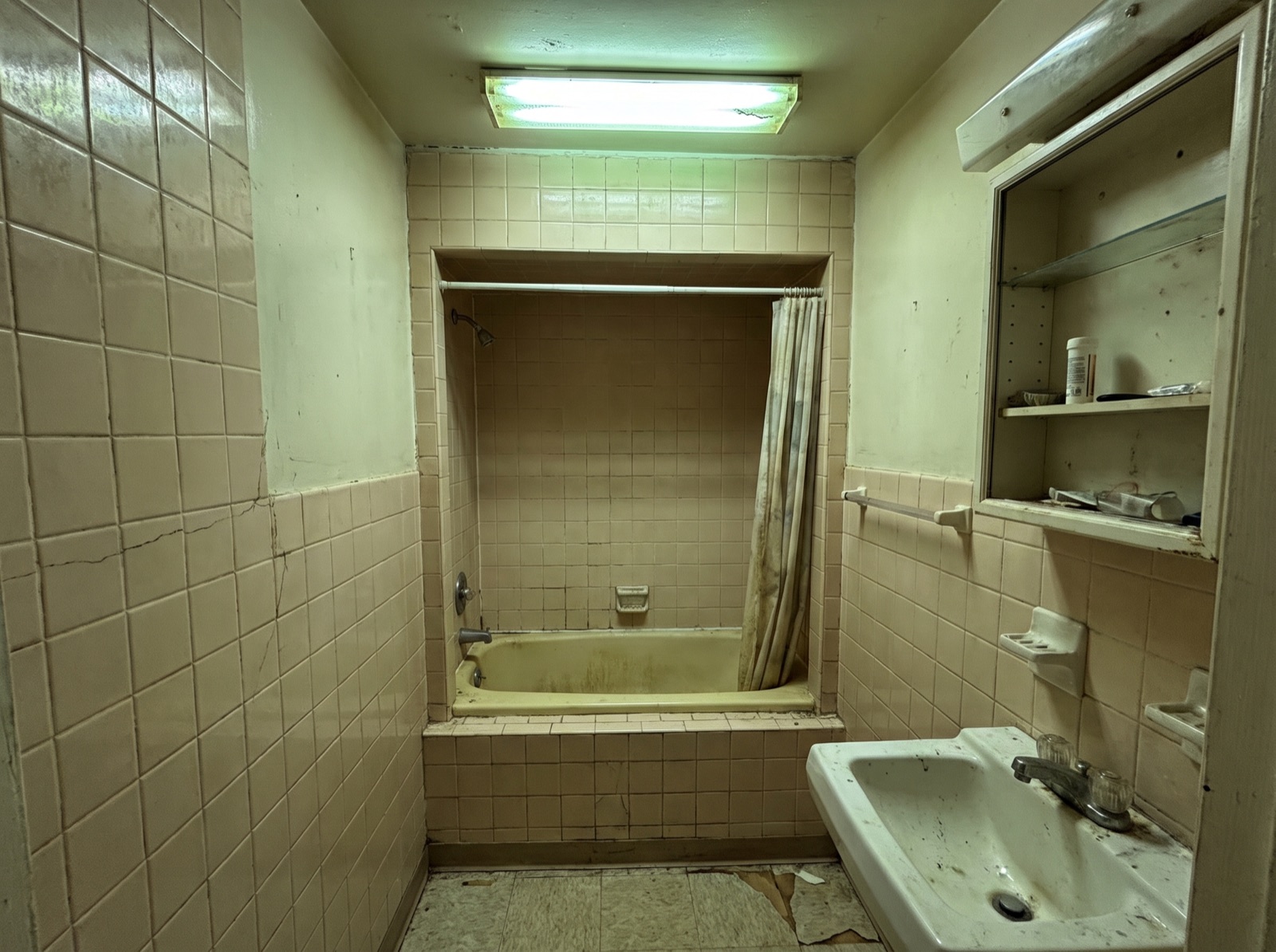 Badezimmer vor der Sanierung, altes Bad mit abgenutzten Fliesen